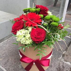 kvetinový box s kvetmi v červenej a zelenej farbe previazaný mašlou